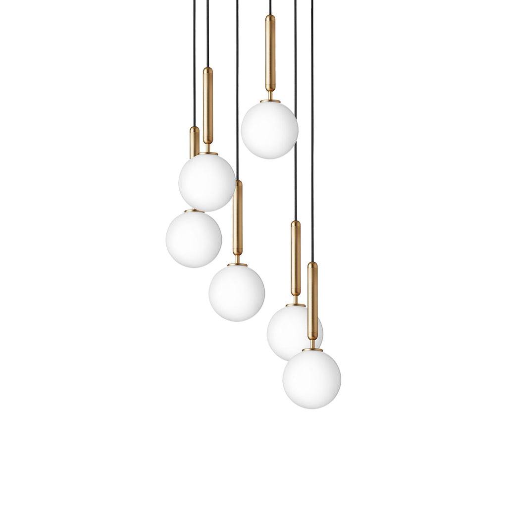 Clérachic pendants with white opal globes on brass rods, hung in a mixed-height cascade on a plain white background.