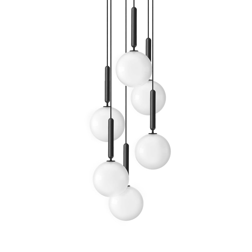 Seven black-rod Clérachic pendants with white opal globes hang in a loose cascade on a plain white background.
