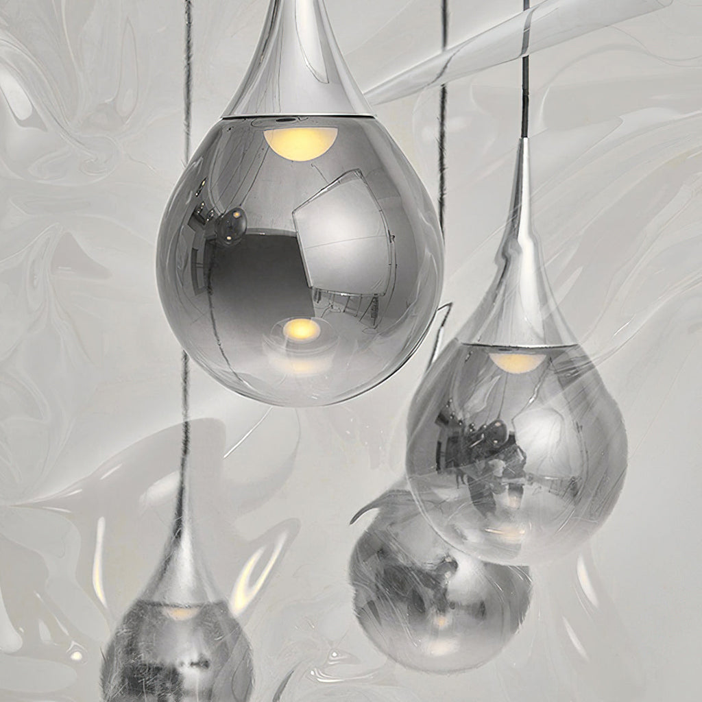 Close view of chrome-finish Clérachic pendants, their mirrored glass shades reflecting the room and a warm bulb inside each.
