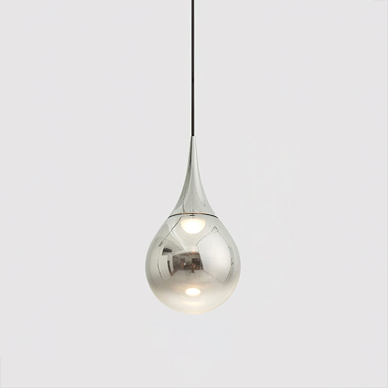 Chrome-finish Clérachic pendant with a mirrored shade and a warm bulb visible within, on a light grey backdrop.