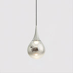 Chrome-finish Clérachic pendant with a mirrored shade and a warm bulb visible within, on a light grey backdrop.