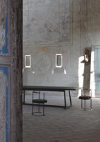 Two Clérachic pendants hang over a long dark table in a vaulted stone room with faded frescoes.