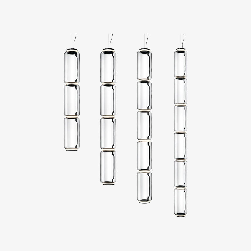 Four clear glass cylinder columns in different lengths hang side by side, Clérachic pendants on a plain white backdrop.