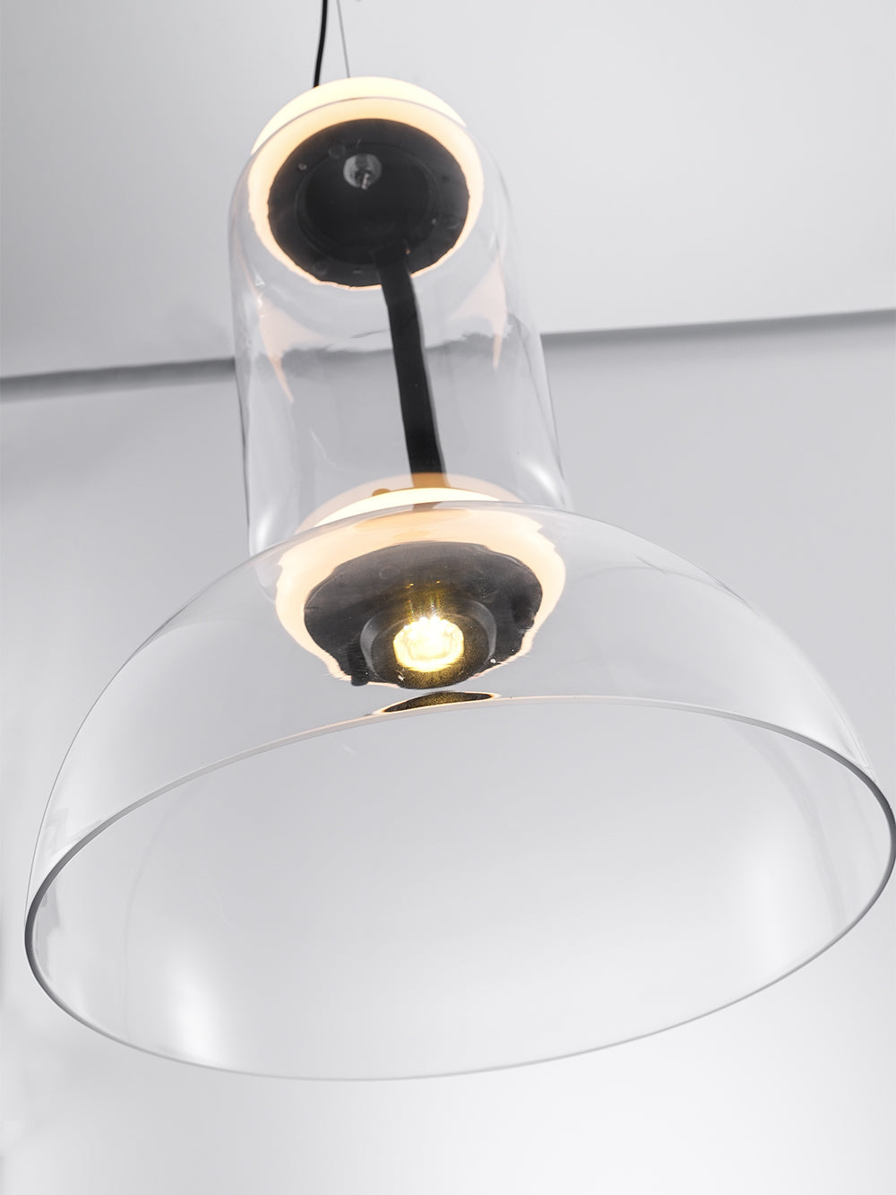 Looking up into the dome of this Clérachic pendant, at the small light source and the glowing ring above it.