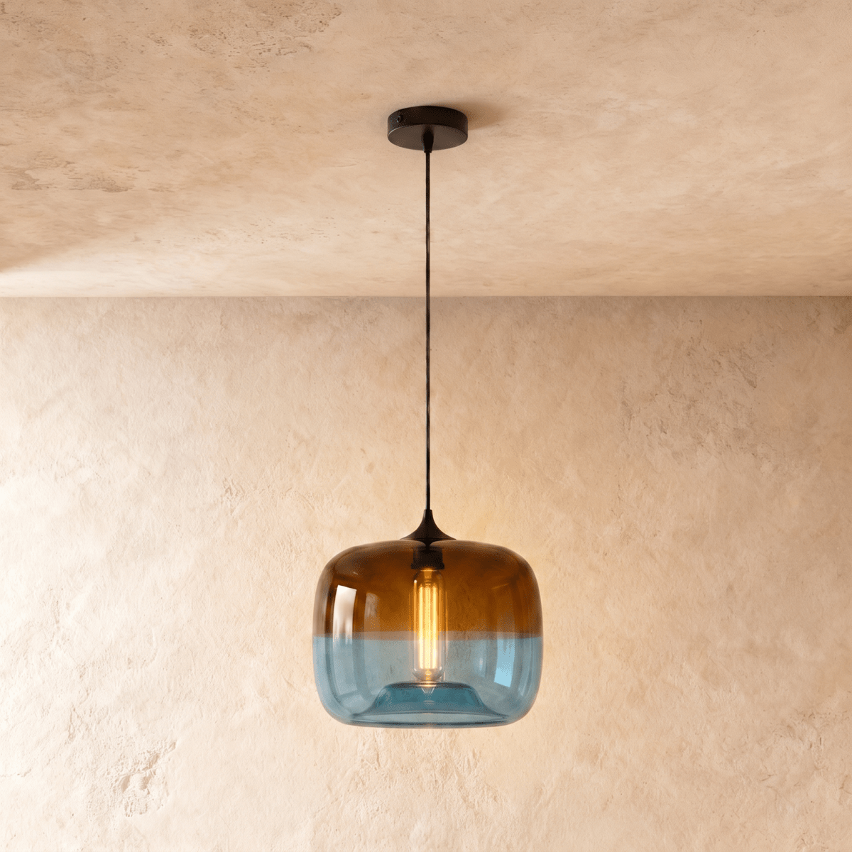 Clérachic glass pendant in amber fading to blue, lit by a warm filament bulb, hung on a black cord from a black canopy.