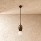 Clérachic pendant with a smoked glass capsule over a frosted white globe, unlit, hanging from a black cord and round canopy.