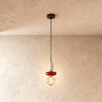 Clérachic compact pendant of a white capsule, red glass disc and clear globe with a visible filament-style LED strip.