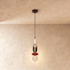 Clérachic four-tier pendant: frosted capsule, smoked capsule, red disc and opal globe, hanging from a slim black cord.
