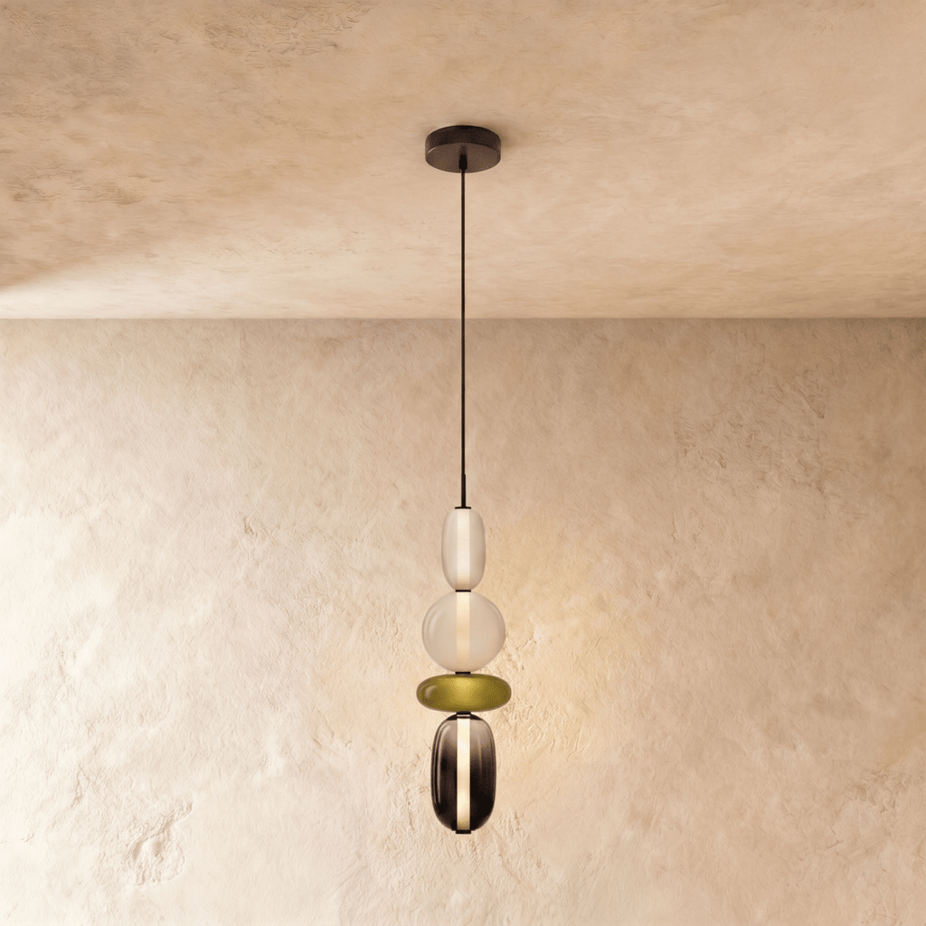 Clérachic long pendant stacking a frosted capsule, opal globe, olive disc and smoked glass capsule on a black cord.