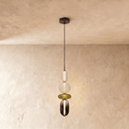 Clérachic long pendant stacking a frosted capsule, opal globe, olive disc and smoked glass capsule on a black cord.