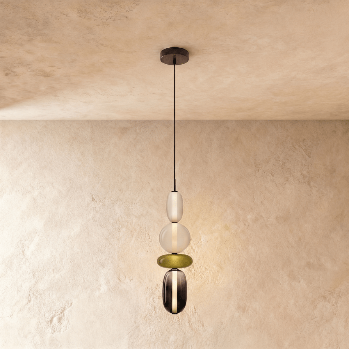 Clérachic long pendant stacking a frosted capsule, opal globe, olive disc and smoked glass capsule on a black cord.