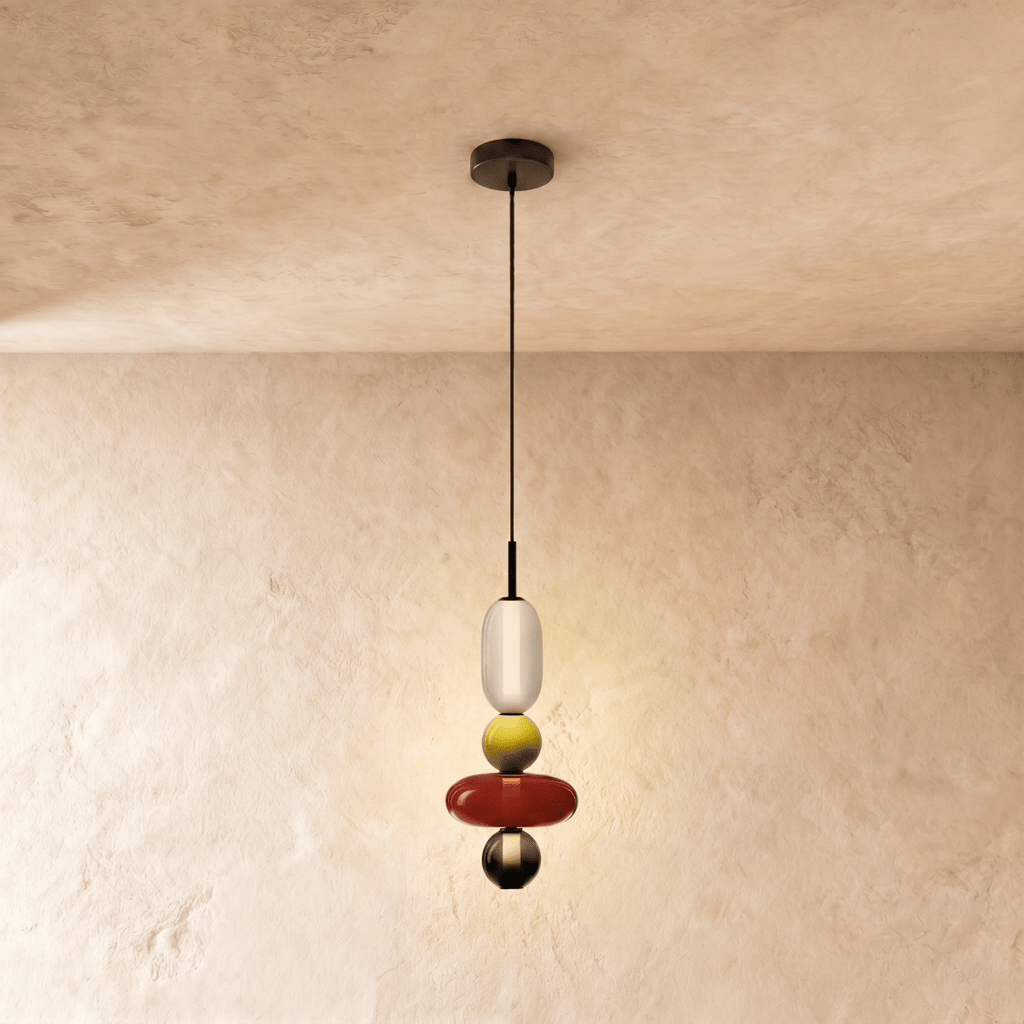 Clérachic pendant with a white capsule, chartreuse bead, broad red disc and small smoked bead on a limewash backdrop.