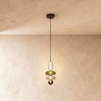 Clérachic slim pendant of a frosted capsule, olive disc, white disc and a small smoked glass bead, softly lit.