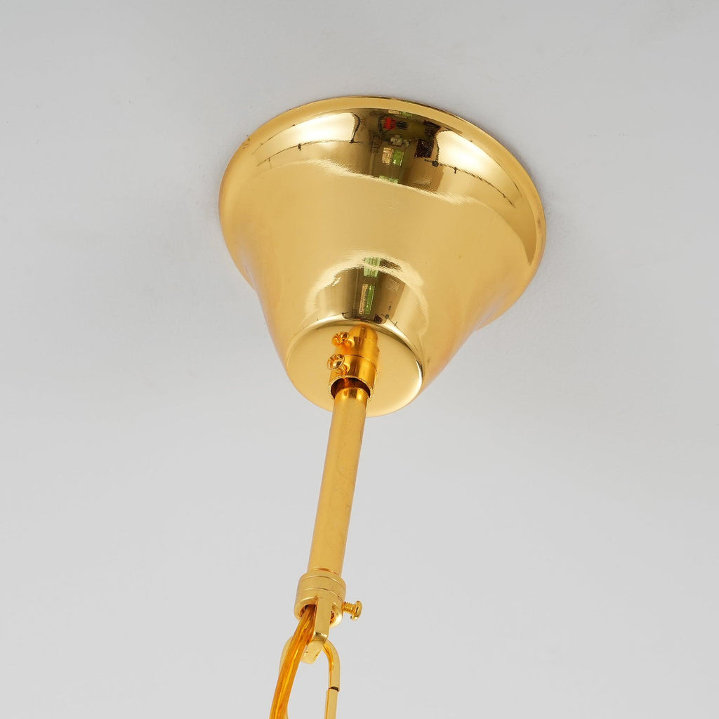 Close view of the polished gold canopy and the rod and chain link above this Clérachic chandelier.