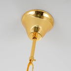 Close view of the polished gold canopy and the rod and chain link above this Clérachic chandelier.