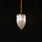 Small narrow looped-glass Clérachic chandelier with a gold top, hung from a twisted cord against a black backdrop.