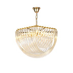 Clérachic chandelier with curved clear glass rods and a gold top frame, lit warmly on a short gold chain against white.