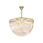Gold-framed Clérachic chandelier with curved clear glass rods lit warmly from within, hung from a gold chain on white.