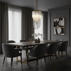 Narrow looped-glass Clérachic chandelier above a long dark dining table with charcoal chairs and white orchids.
