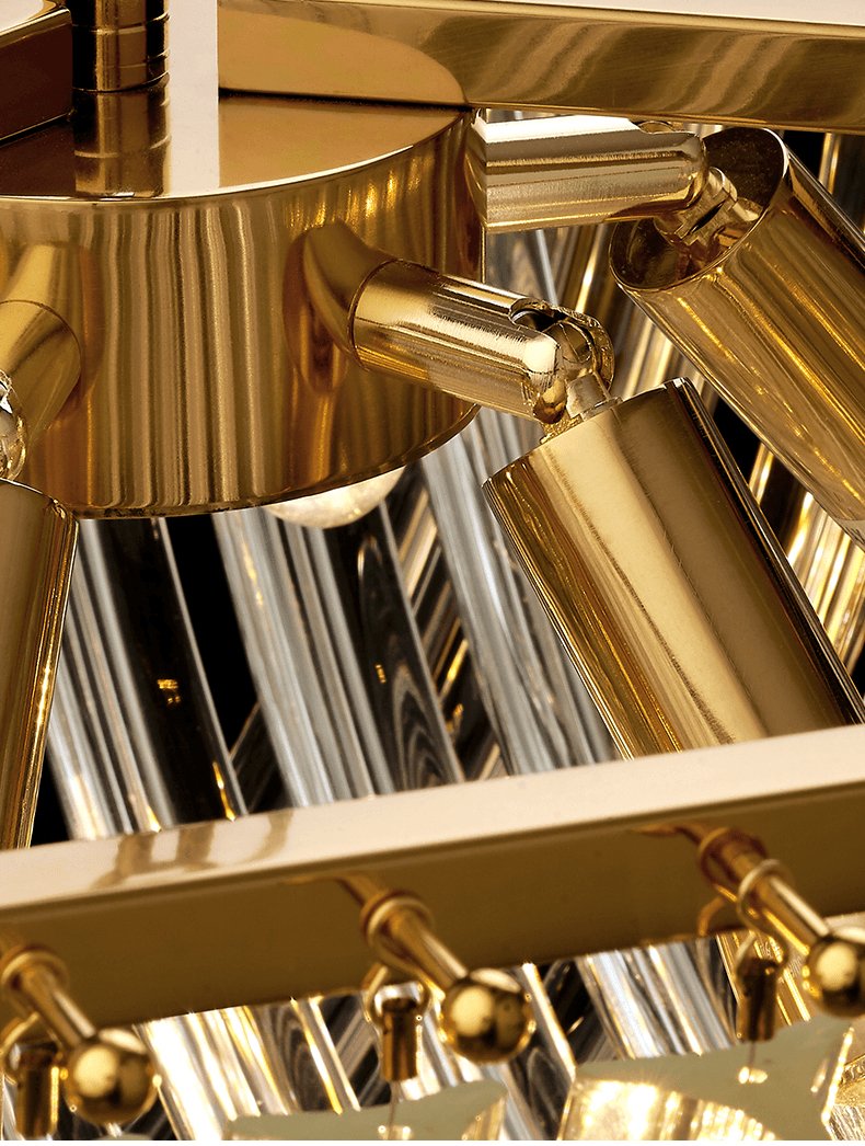 Close view of the gold lamp holders and gold ribbed canopy under the frame of this Clérachic chandelier.
