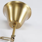 Close view of the brushed gold ceiling canopy, rod and chain link at the top of this Clérachic chandelier.