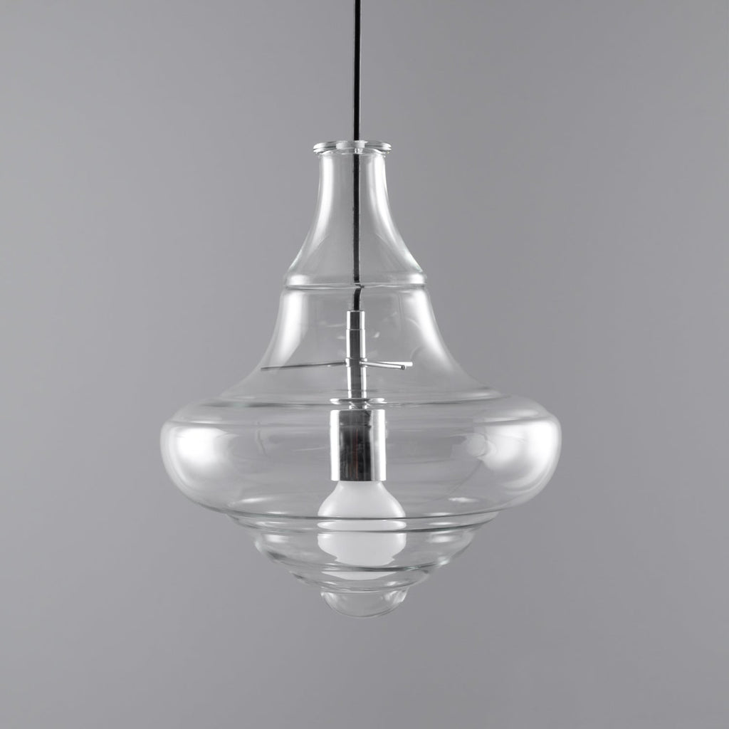 Bell-shaped clear glass pendant from Clérachic with an unlit bulb visible inside, on a grey backdrop.