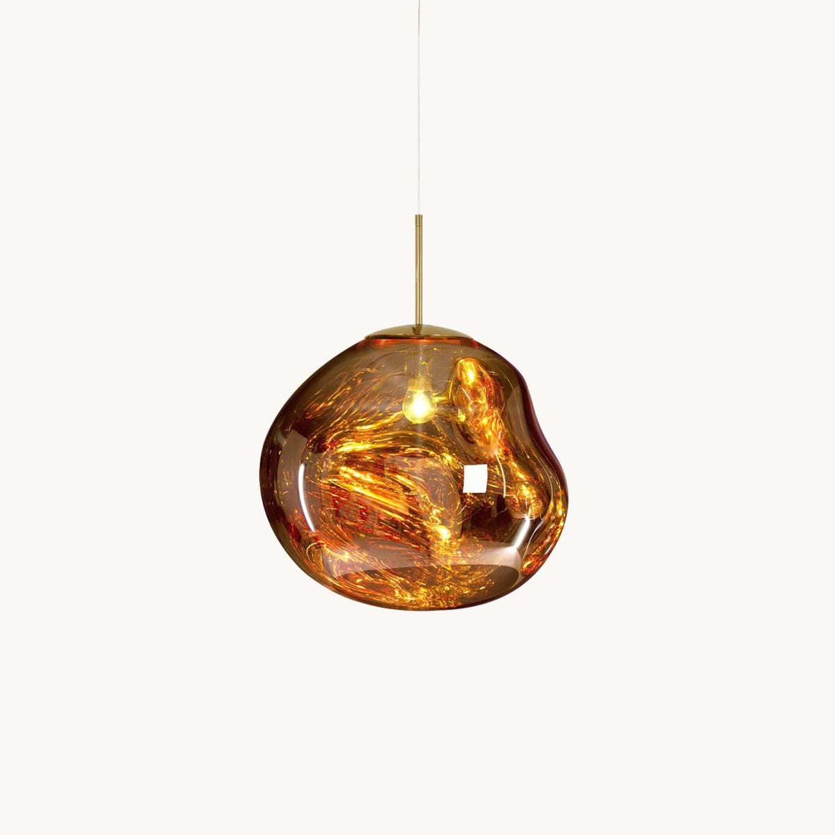 This Clérachic pendant light on a plain white backdrop, in gold, with a glossy, irregular molten-looking glass shade and a slim brass rod.