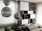 Two Clérachic silver glass pendants hang beside a glossy white cabinet and shelving, above a sofa and a bunch of white flowers.