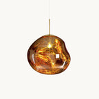 This Clérachic gold pendant on a white backdrop, with a glossy molten-looking glass shade, a lit bulb and a brass rod above.