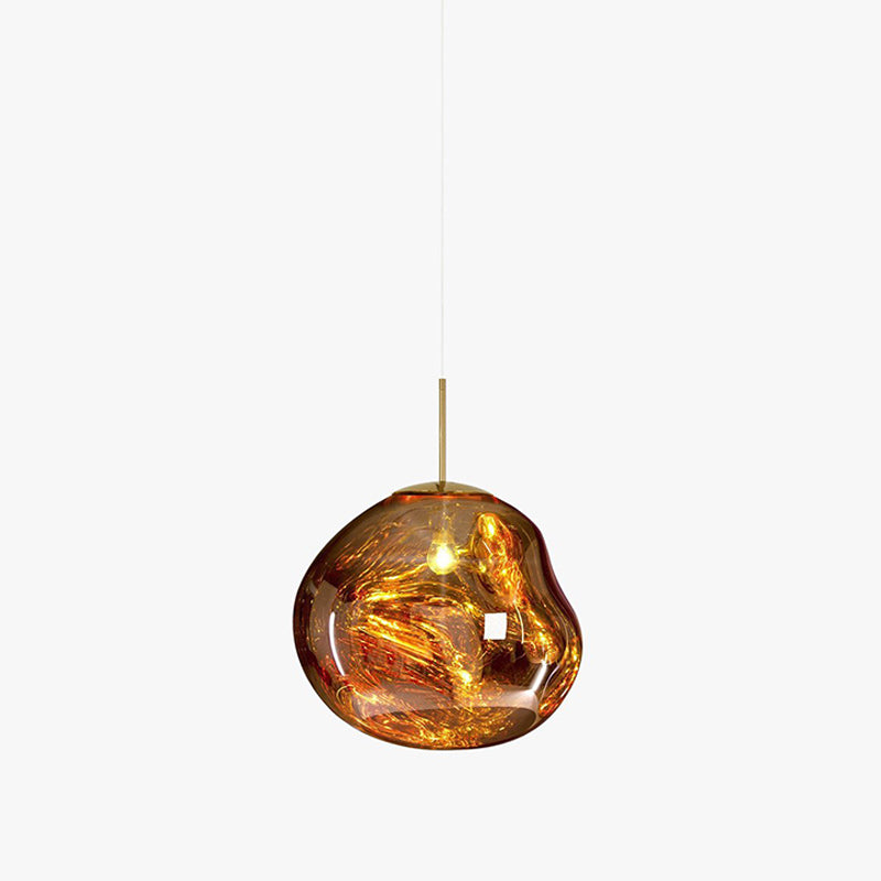 A small Clérachic gold glass pendant on a white backdrop, with a brass rod and a molten-looking shade around a bright bulb.
