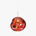 A Clérachic copper-red glass pendant on a pale backdrop, with a thin silver rod and a rounded, uneven glass shade.