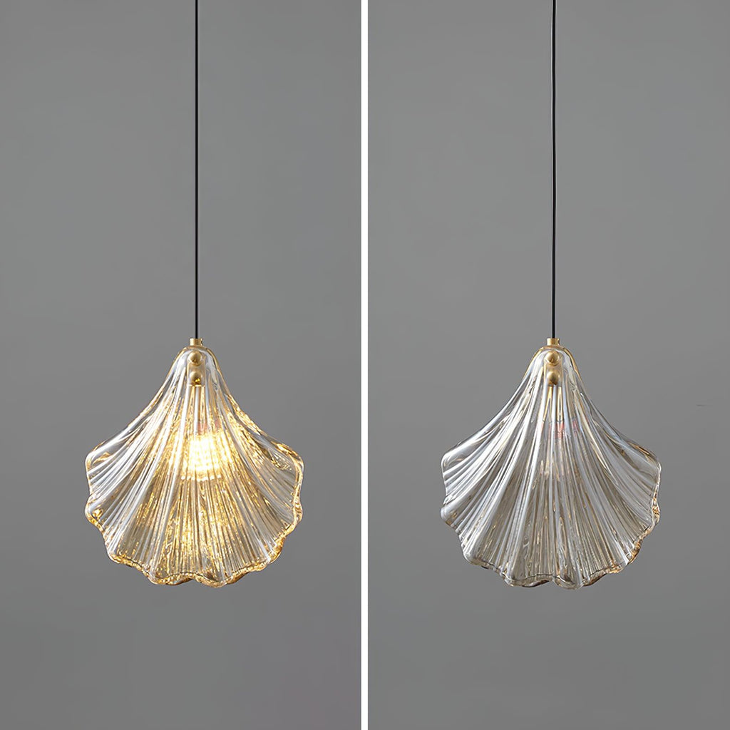 Side-by-side views of a Clérachic shell pendant on grey, one lit with an amber rim and one unlit and plain clear.