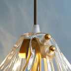 Close view of the cord entry, white ceramic holder and gold ball detail at the top of this Clérachic shell pendant.