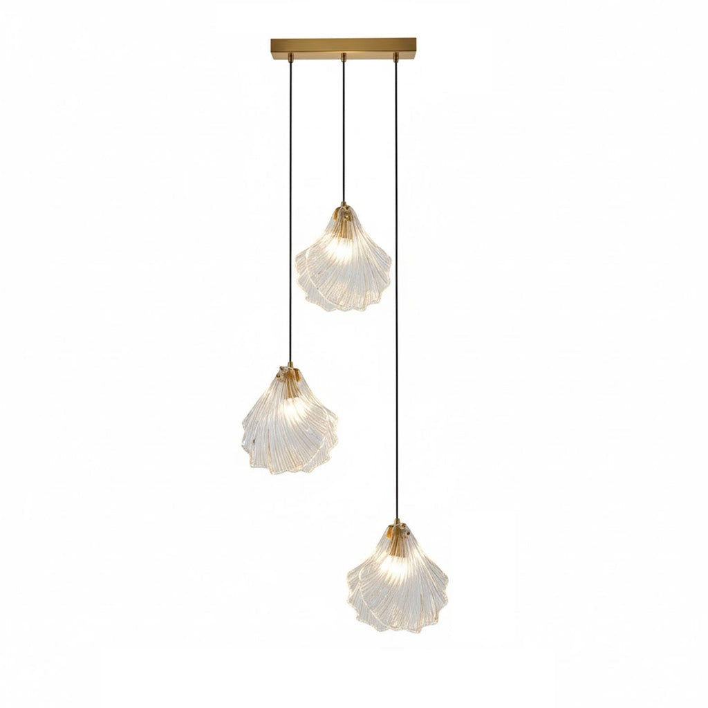 A Clérachic three-light pendant with clear glass shells hangs at three lengths from a straight brass bar, on white.