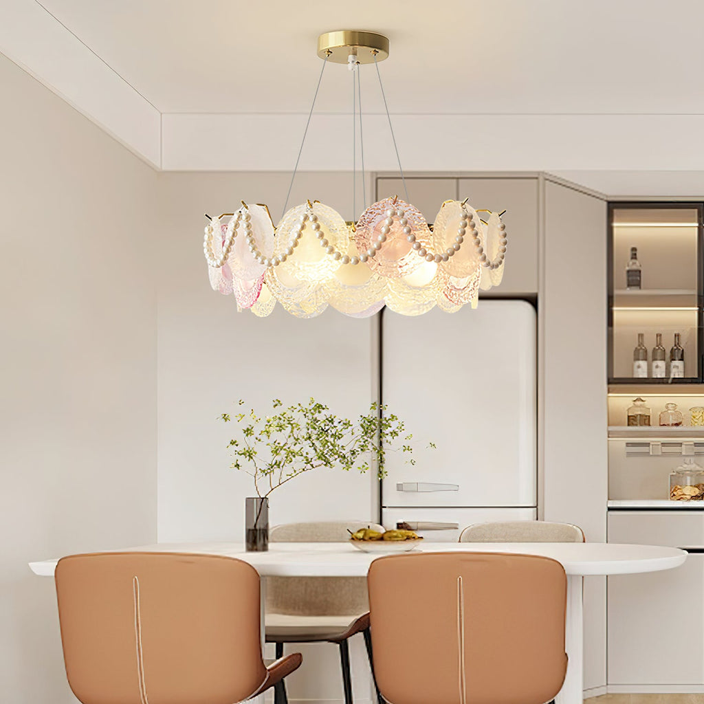 This Clérachic pendant with pearl swags across its glass discs hangs over a white oval dining table with tan leather chairs.