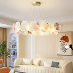 Clérachic round pendant lit in a living room, with a cream curved sofa, an arched shelf niche and a leaf-print picture on the wall.