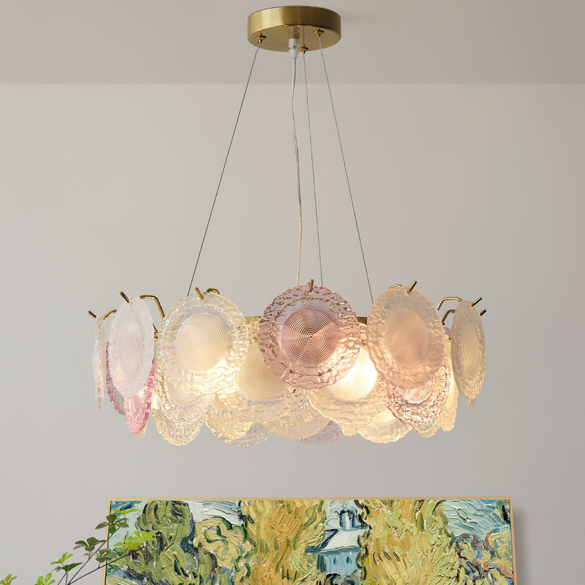 Looking slightly up at a Clérachic pendant with a ring of ridged pink and frosted glass discs, with a painted landscape below.