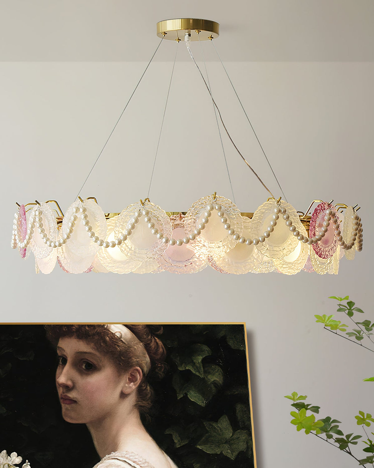 This Clérachic pendant with pearl swags hangs wide, with a portrait painting and leaf sprigs in the corners of the frame.