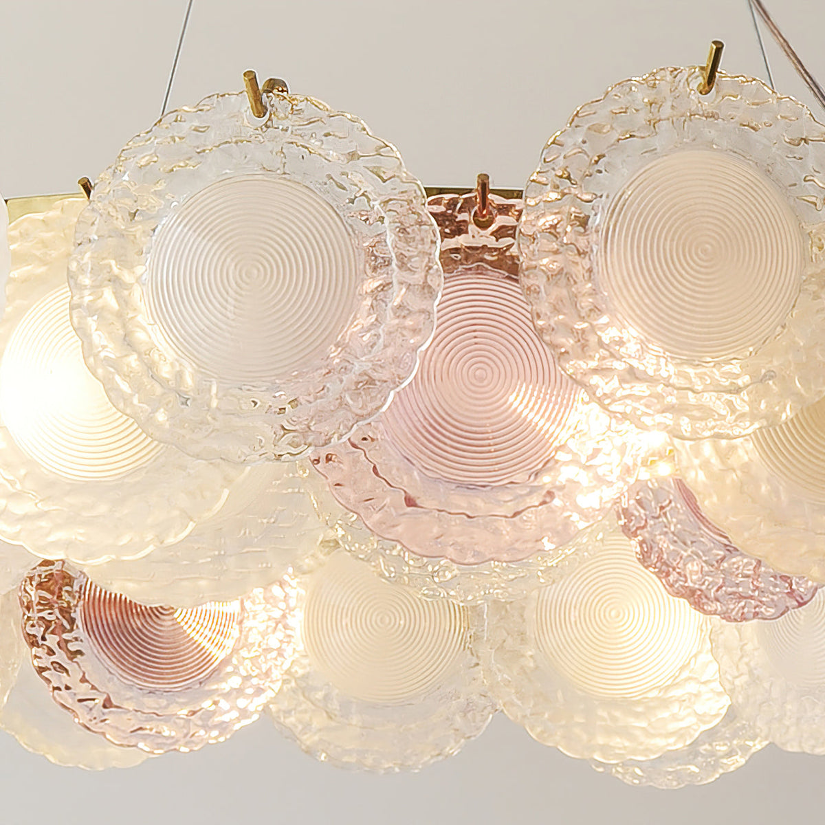 Close view of the concentric ridges on the pink and frosted glass discs of this Clérachic pendant.