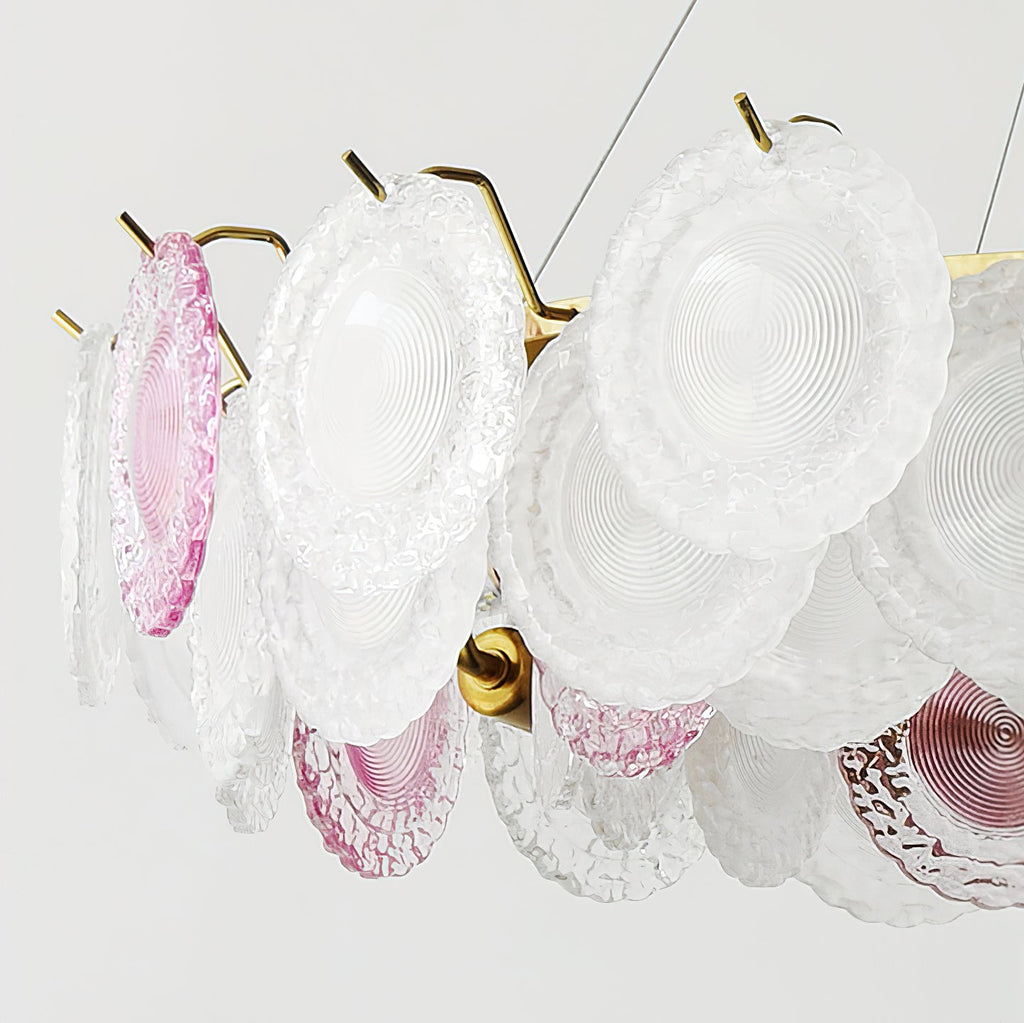 Close view of the clear and pink glass discs on this Clérachic pendant, held on gold hooks.