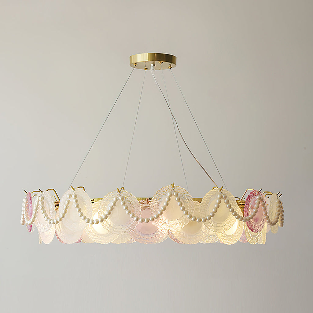 This Clérachic pendant, lit, with pearls looped across its ring of frosted and pink glass discs on a plain wall.