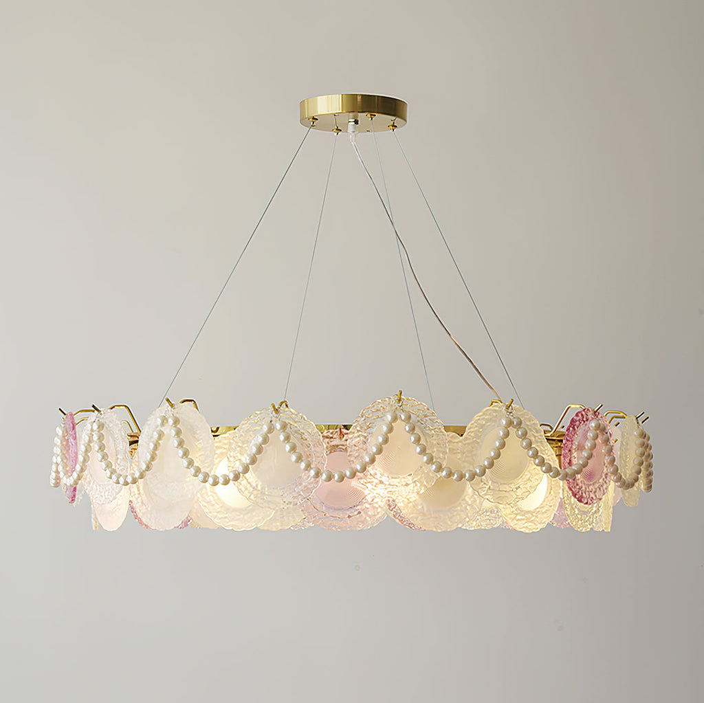 A wide Clérachic pendant with looped pearls and glass discs, lit, with the three suspension wires visible above it.