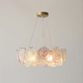 Clérachic pendant of frosted and pink glass discs, lit, with a compact ring shape on a pale grey backdrop.