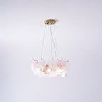 A Clérachic pendant with pink and frosted glass discs, lit, hung on three wires against a pale lilac wall.