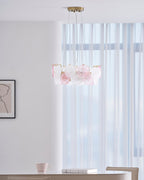 A small Clérachic ring pendant in a bright room with sheer curtains, a framed print and a table with a cup and a book.