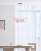 A distant view of the Clérachic pendant in a bright dining area, with sheer curtains and a table with chairs below.