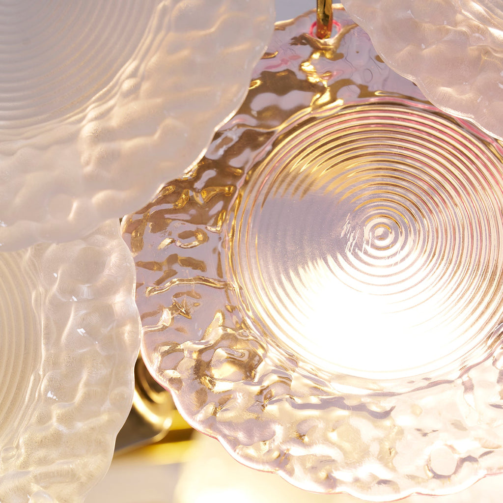 Close view of a pink disc on this Clérachic pendant, with light shining through its ridged centre.