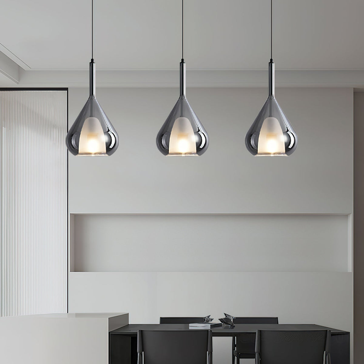 Three Clérachic smoke grey glass pendants above a black dining table, with a built-in shelf niche in a grey wall behind.
