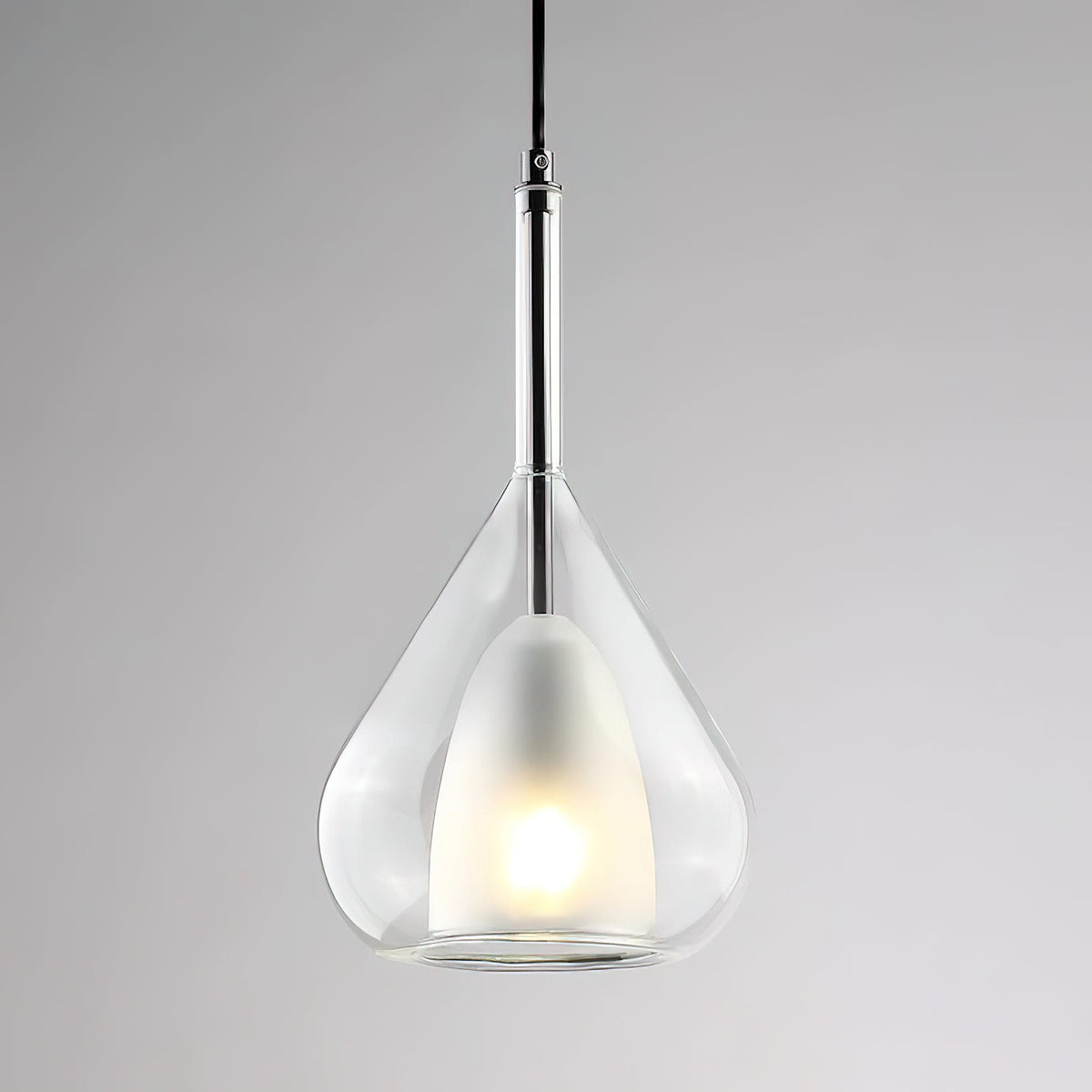 Clear glass teardrop pendant from Clérachic with a frosted inner shade and a chrome-coloured stem, on a soft grey backdrop.