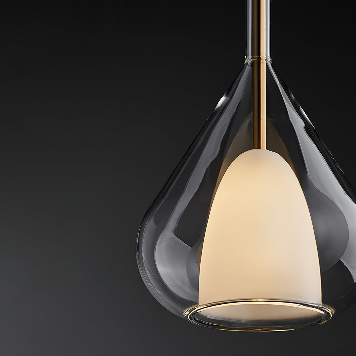 Clérachic smoke grey glass pendant on a black backdrop, with a brass stem above and a lit frosted inner shade inside the outer glass.